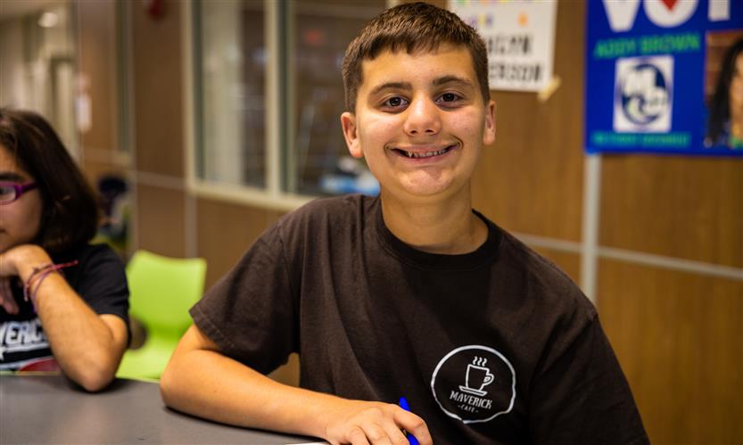 A boy wearing a black t-shirt smiles